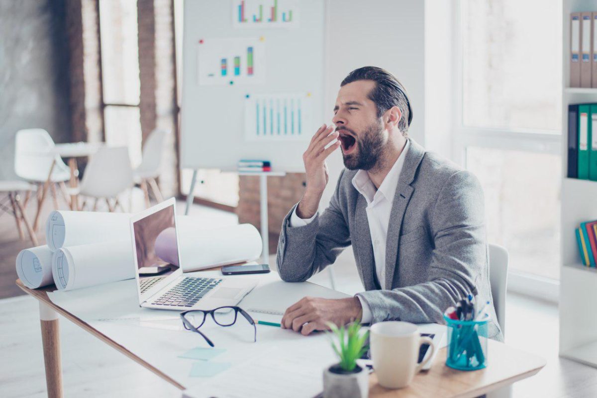 Man yawning at desk | SleepTest.co.uk