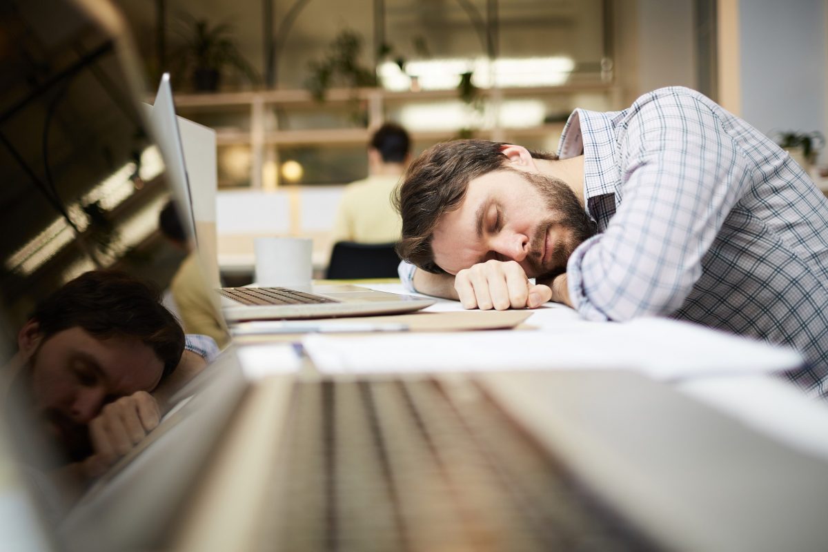 Man asleep at his desk - Can stress cause Sleep Apnoea? blog header image | SleepTest.co.uk