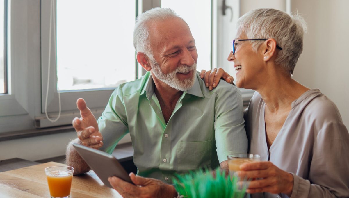 Older couple smiling in kitchen | SleepTest.co.uk